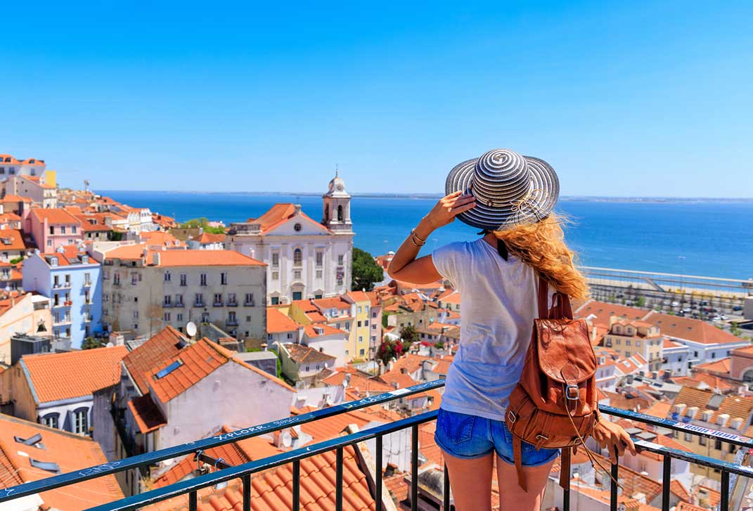 Woman on a viewpoint looking at panoramic view of Lisbon in Portugal.