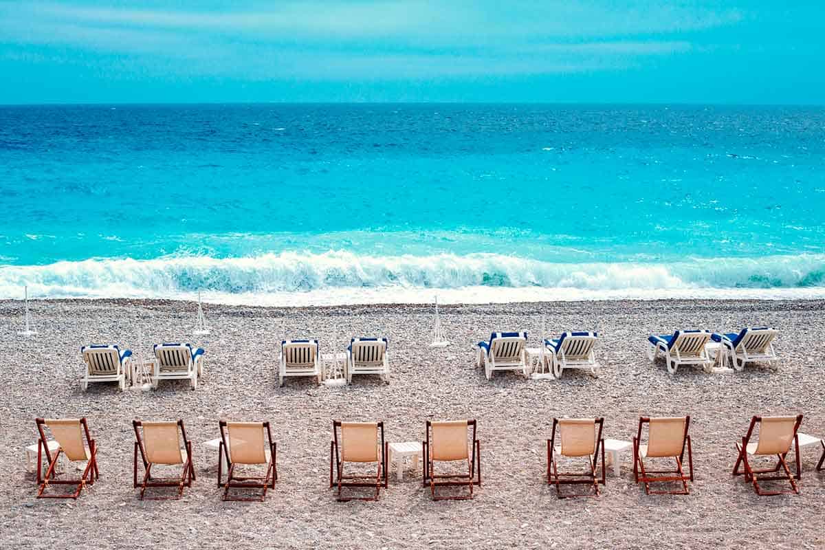lounge chairs in the sand at a beach club in the French Riviera