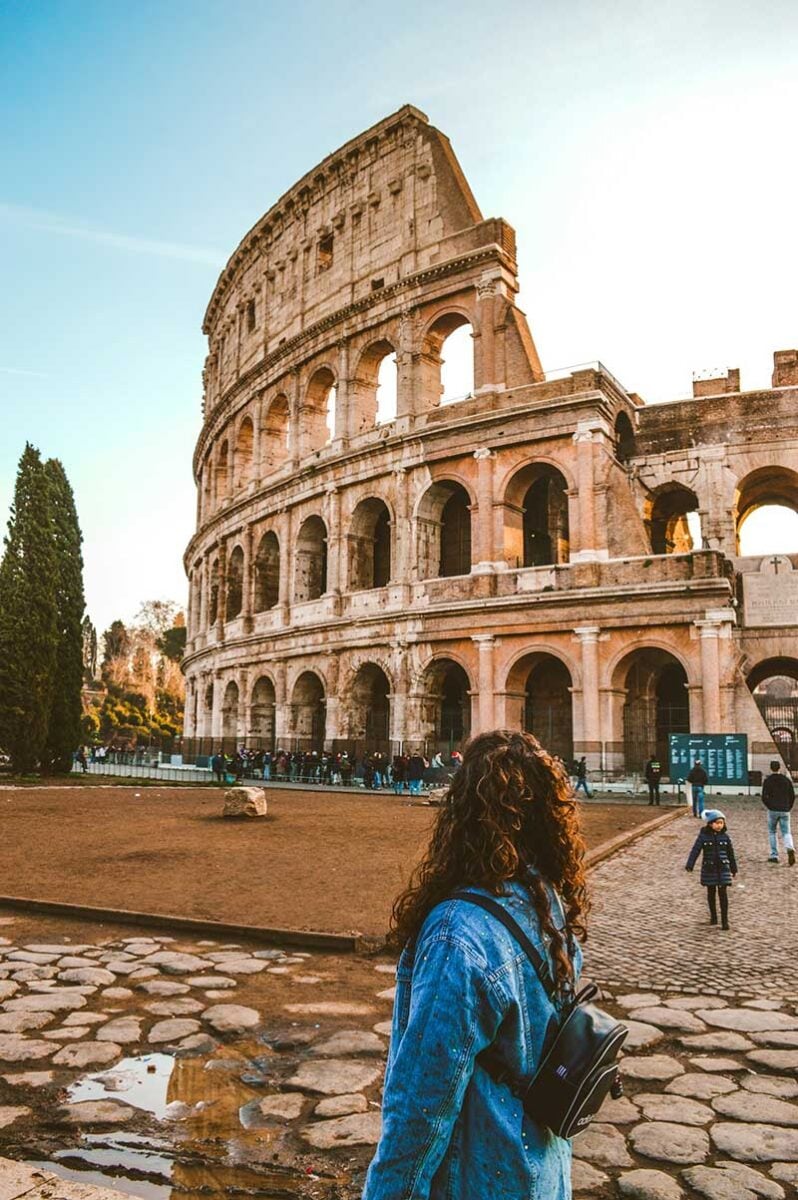 Close up photo of a woman looking at the Colosseum in Rome, Italy, on her solo trip to Rome.