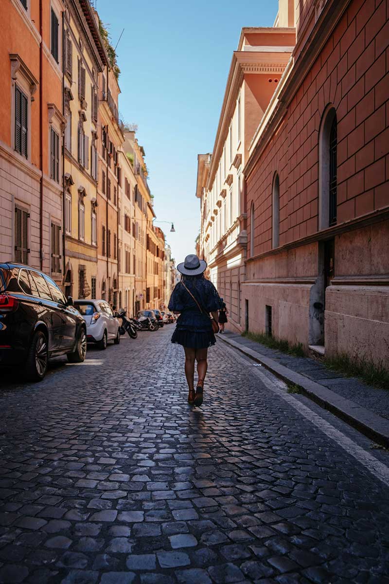 A woman walking down a street in Rome, Italy.