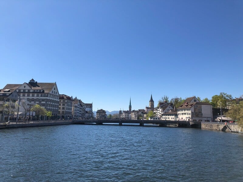 woman taking in a view over The Limmat river in Zurich on during solo travel in Switzerland
