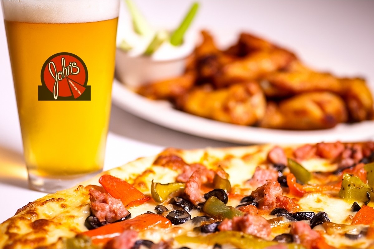 A photo of a pizza, pint of beer and chicken wings from John's Times Square, NYC.