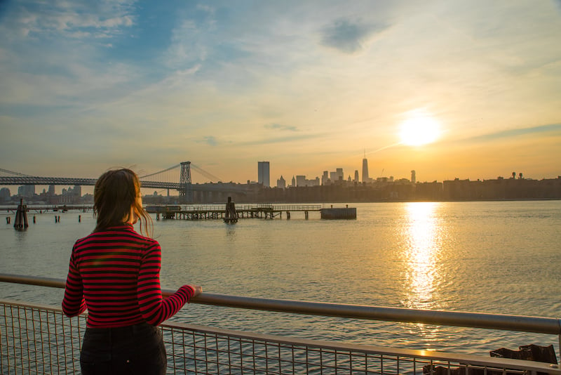woman watching the sunset over the Manhattan skyline from Williamsburg, Brooklyn