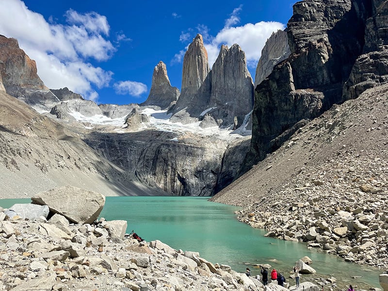 solo traveler in South America reaching the the towering spires Torres del Paine in Patagonia while hiking the W Trek