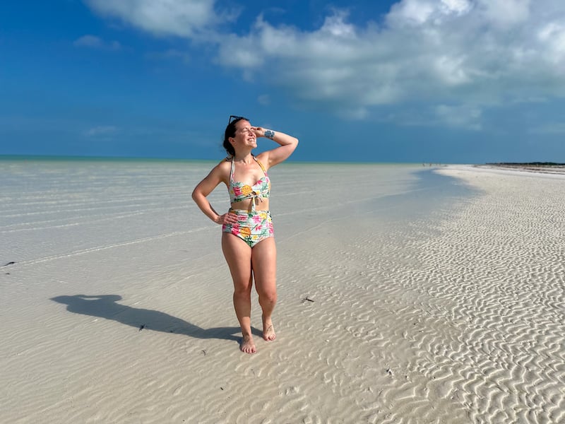 woman in a bikini posing on a white sand beach in Holbox Island Mexico