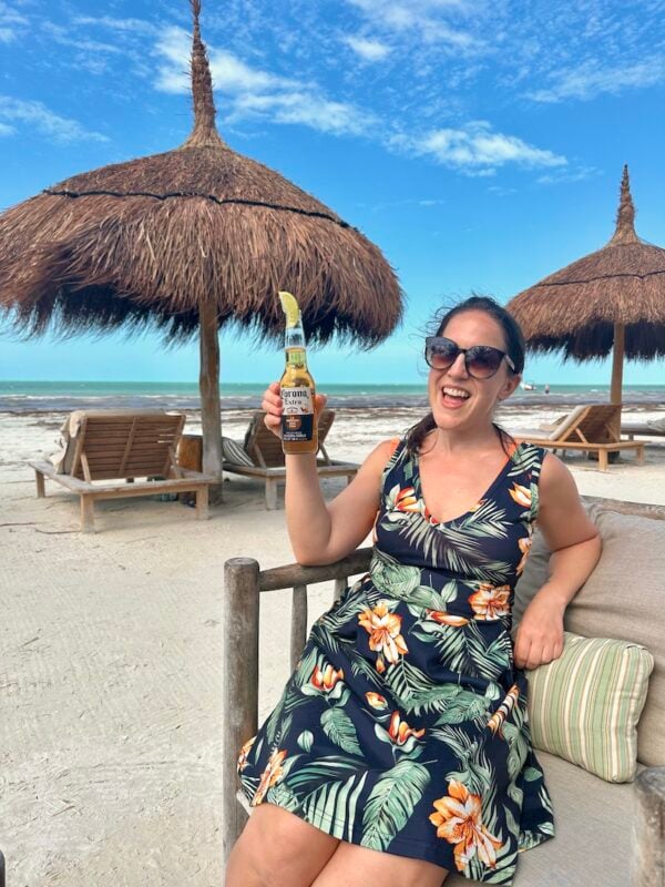 woman drinking a beer at a Playa Holbox beach club