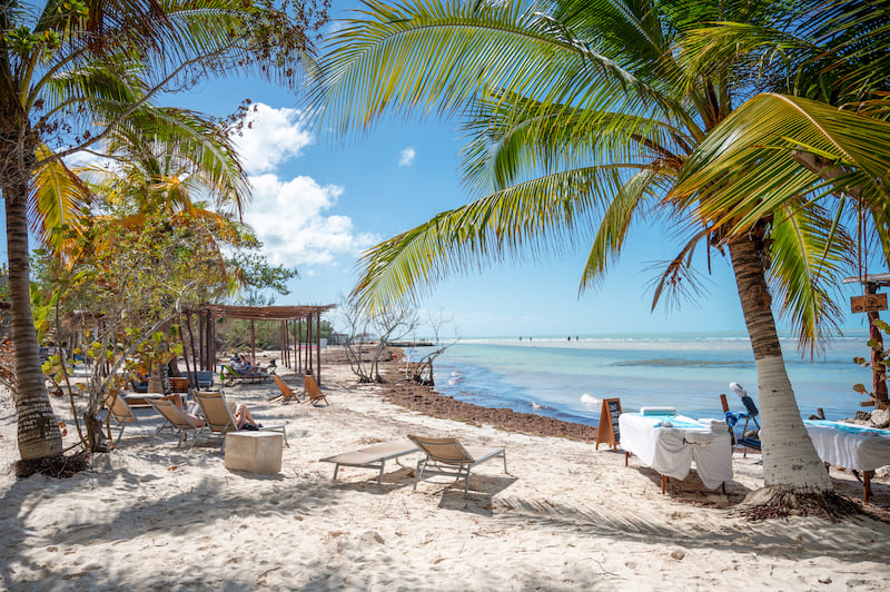 lounge chairs and massage tables on the beach at Las Nubes Holbox Beach Club