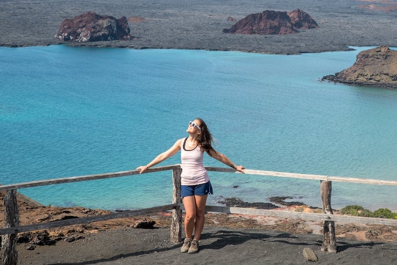 solo female traveler in the Galapagos standing in front of turquoise waters