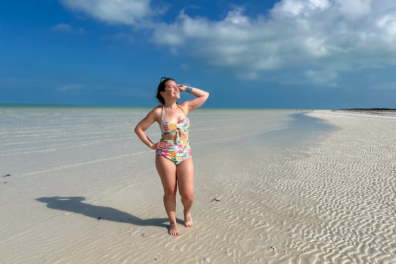 woman posing in a bikini on a white sand beach in Isla Holbox, Mexico