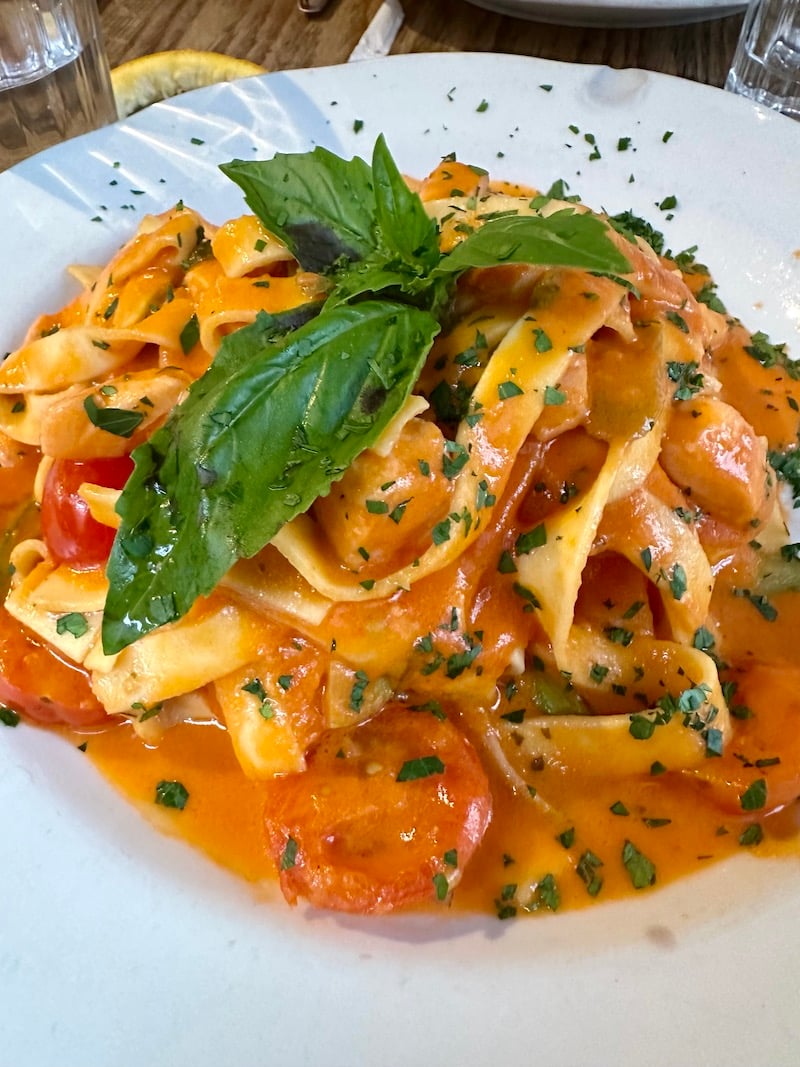 a bowl of salmon pasta at Aria Wine Bar in NYC