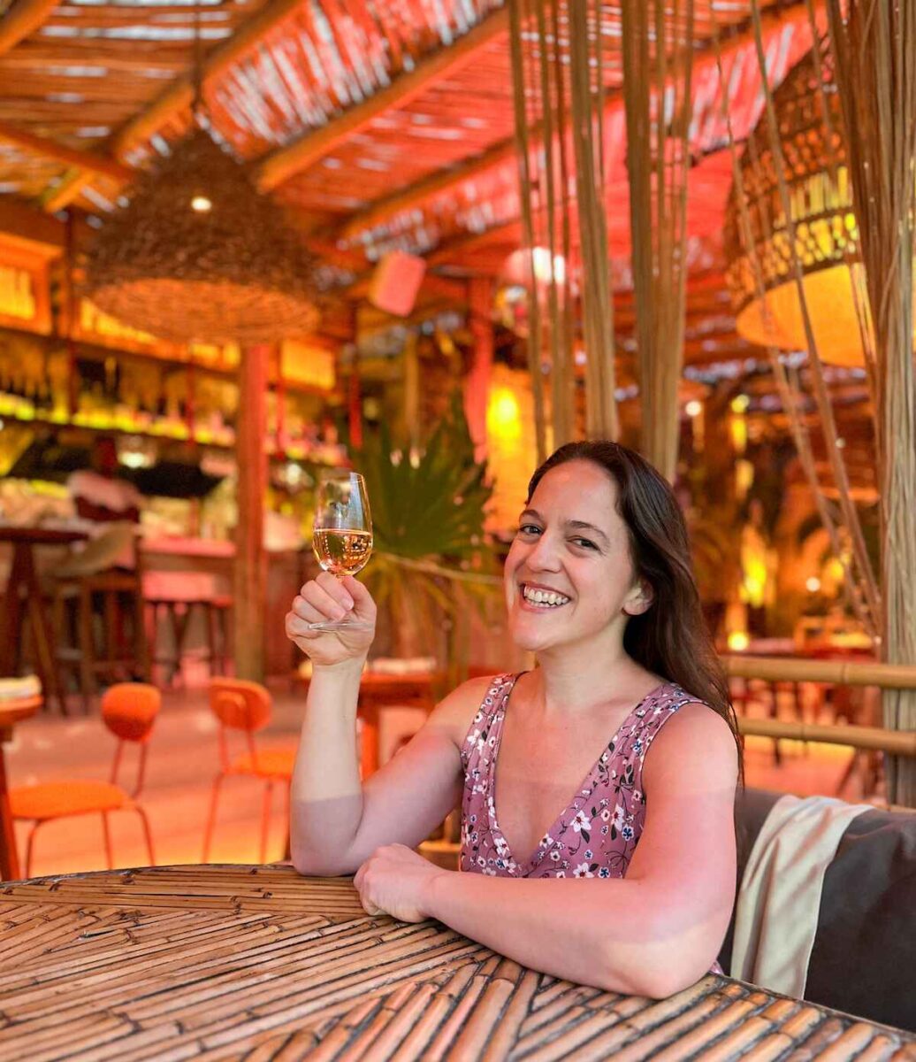 woman holding up a glass of wine at Lazaro Wine Bar on Holbox Island, Mexico