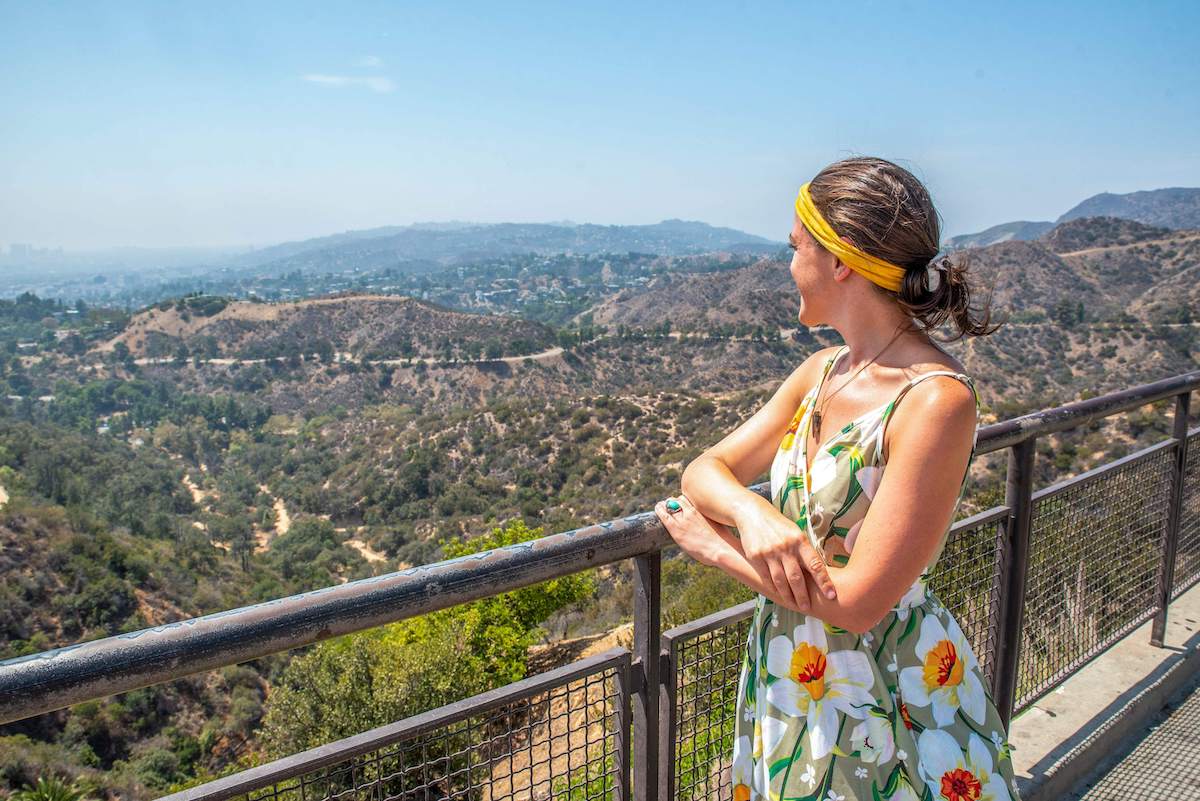 woman looking out at the Hollywood Sign and the Hollywood Hills from Griffith Observatory during a 3 day Los Angeles itinerary