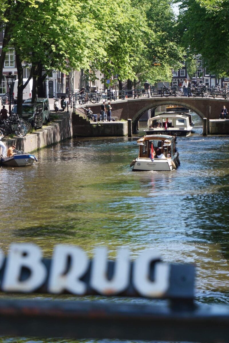 traveler see the famous canals with boats on them on a free walking tour of Amsterdam