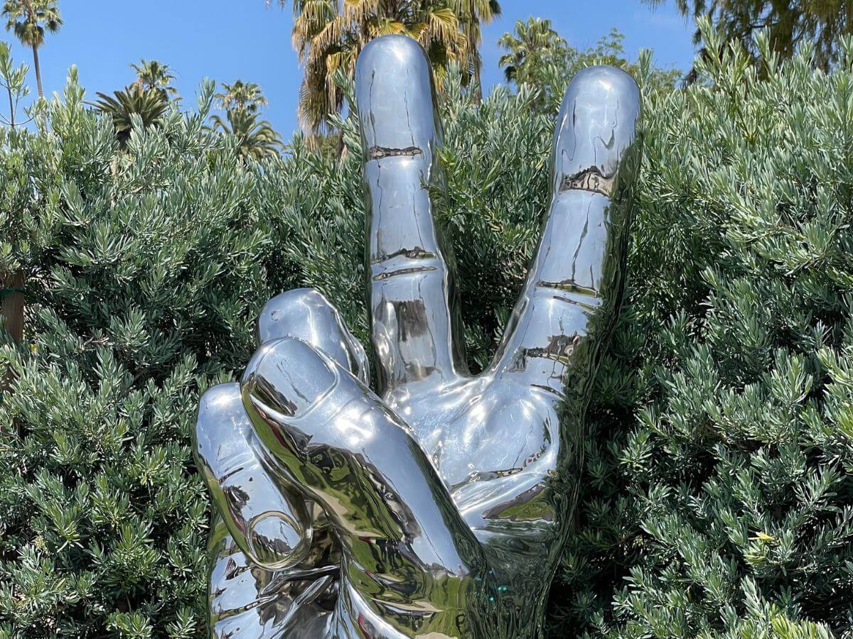 sculpture of a chrome hand giving the peace sign at the Beverly Hills Sculpture Garden in Los Angeles, California