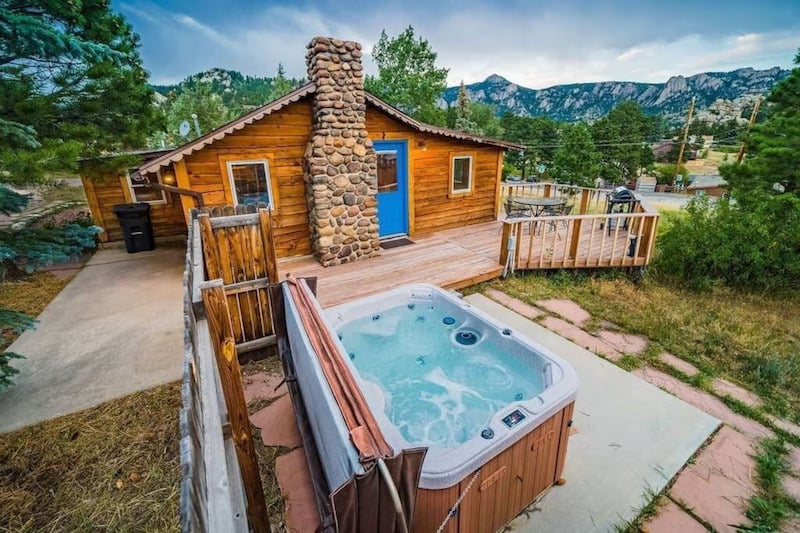 historic cabin in Estes Park, Colorado with a private hot tub in the backyard off the patio