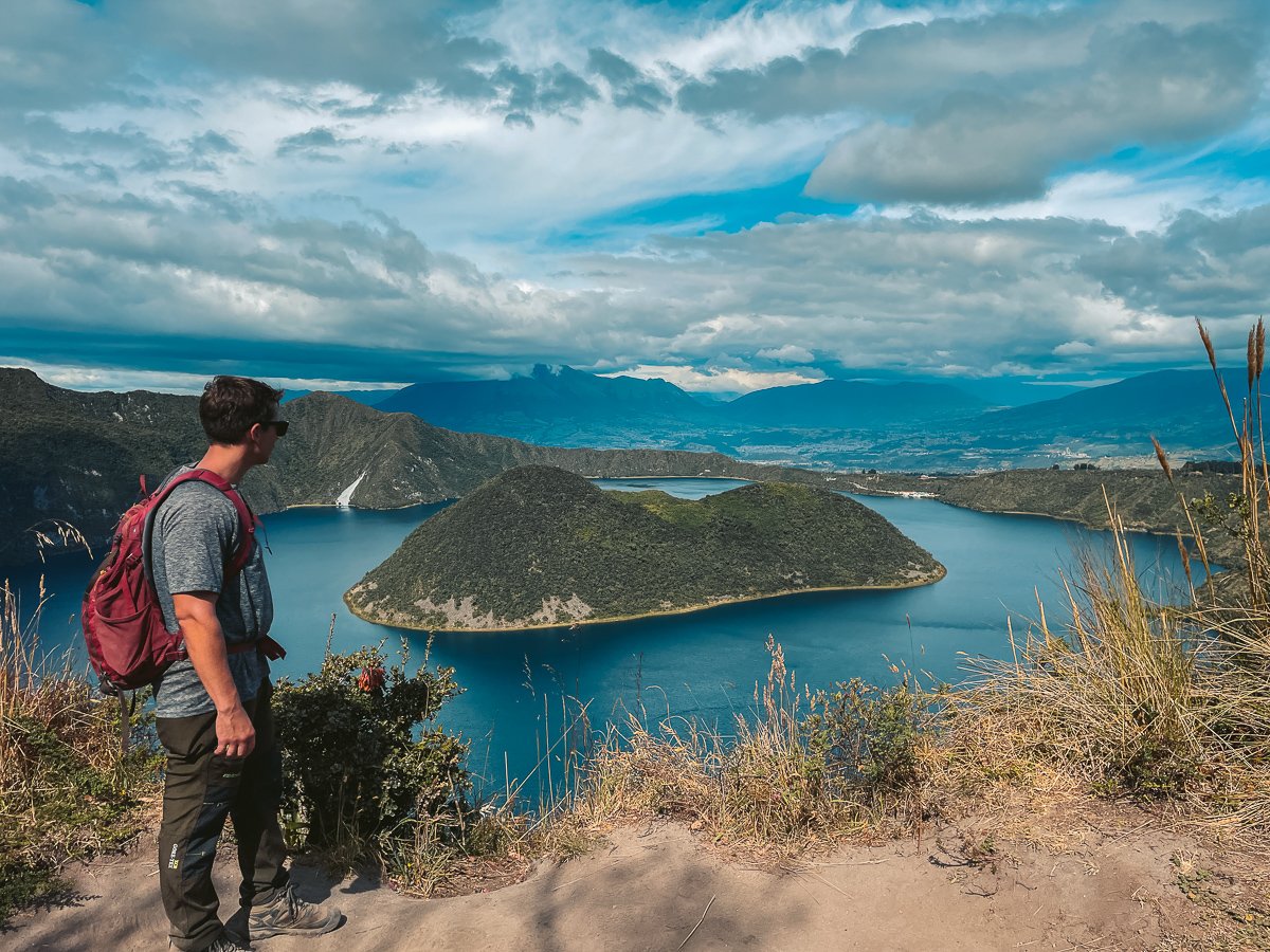 Solo traveler hiking around the picturesque crater lake Cuicocha in Otavalo, Ecuador, surrounded by stunning volcanic landscapes, ideal for exploring on an Ecuador solo travel itinerary.