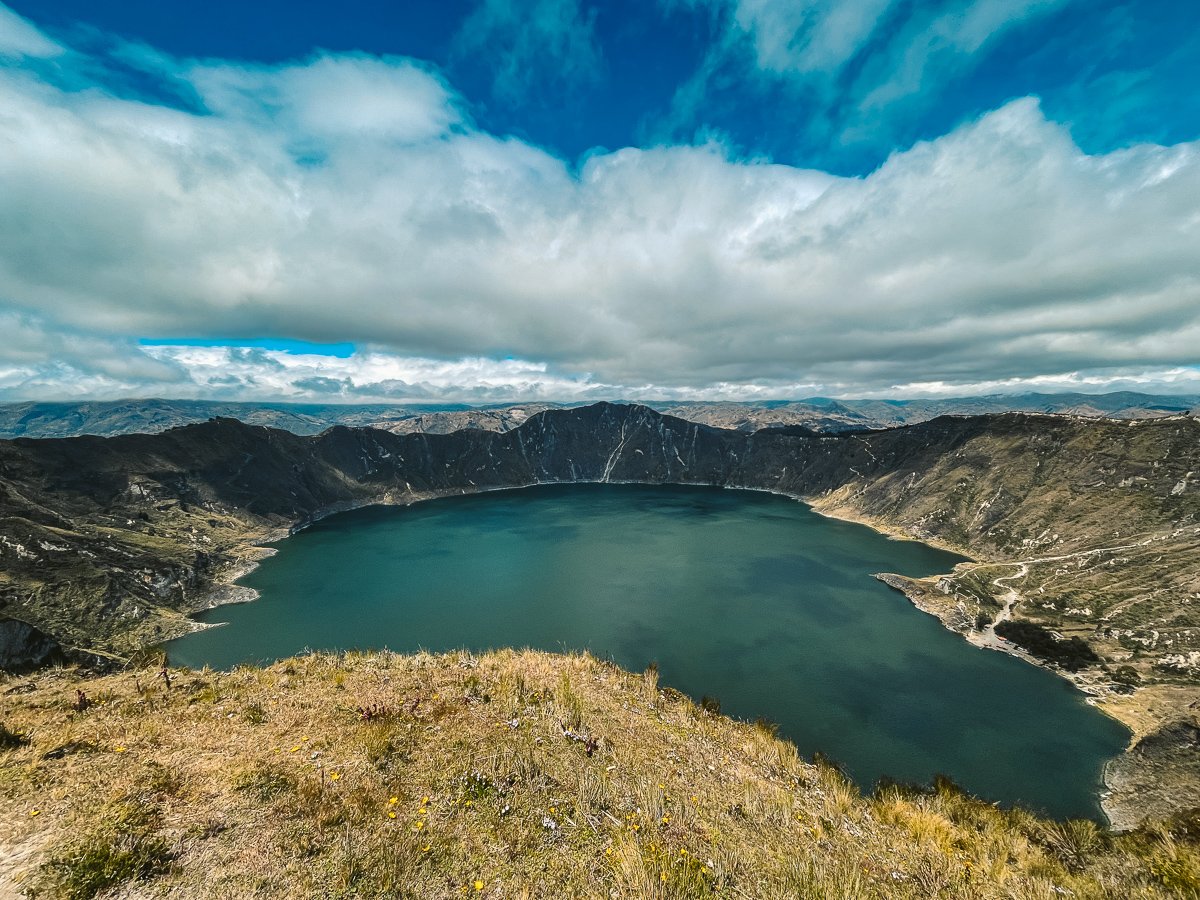 Panoramic view of Laguna Quilotoa after the 3-day trek along the Quilotoa Loop in Ecuador, showcasing the stunning volcanic crater lake and rugged landscape, a rewarding experience for solo travelers and a highlight of an Ecuador itinerary.