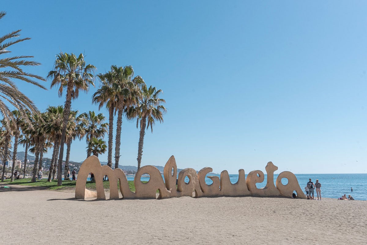 the iconic Malagueta Beach sign on the sand of Malaga, Spain