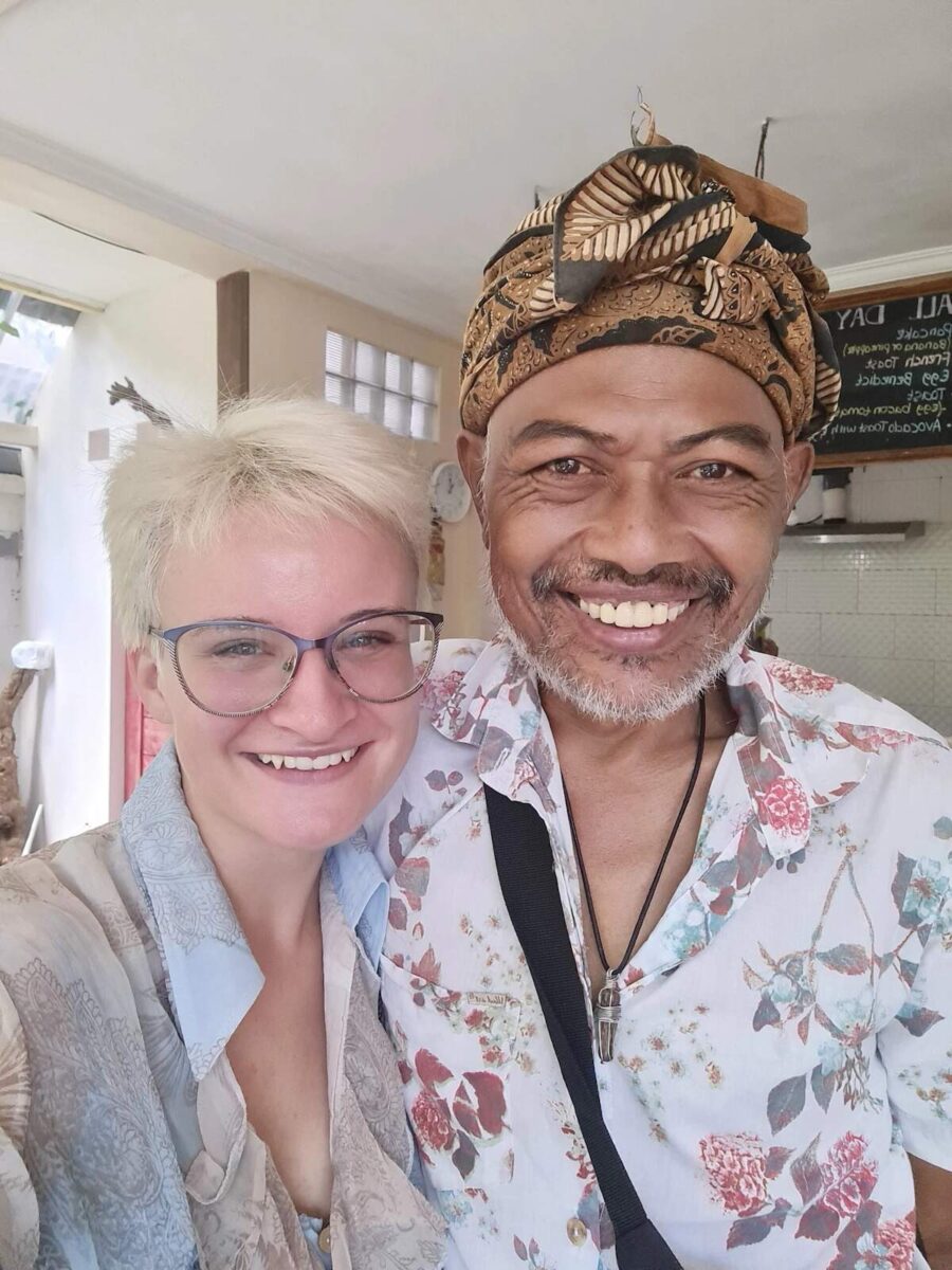 blog post author smiling at the camera next to her host at the Metteya Healing House hotel in Ubud, Bali