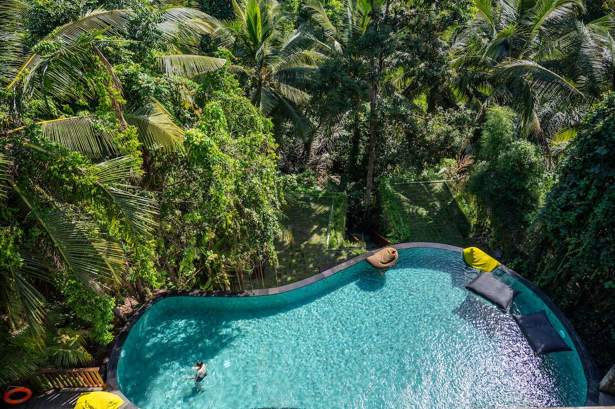Aerial view of the lush, tropical pool area at Adiwana Unagi Suites in Ubud, an ideal accommodation for solo travelers seeking a serene stay in Bali hotels.