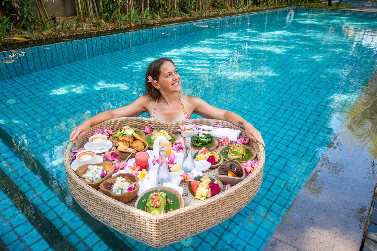 Solo female traveler enjoying a luxurious floating breakfast at a hotel in Ubud, Bali, perfect for solo travelers seeking unique experiences in Bali hotels.