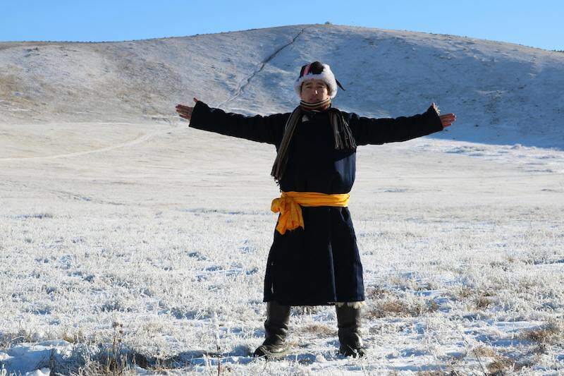 Mongolian man walking in the snow