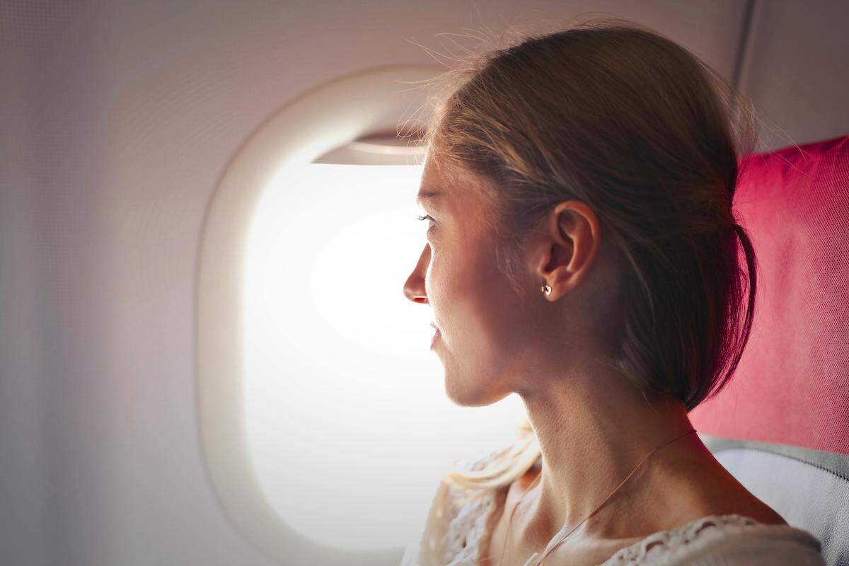 woman flying alone and looking out the window