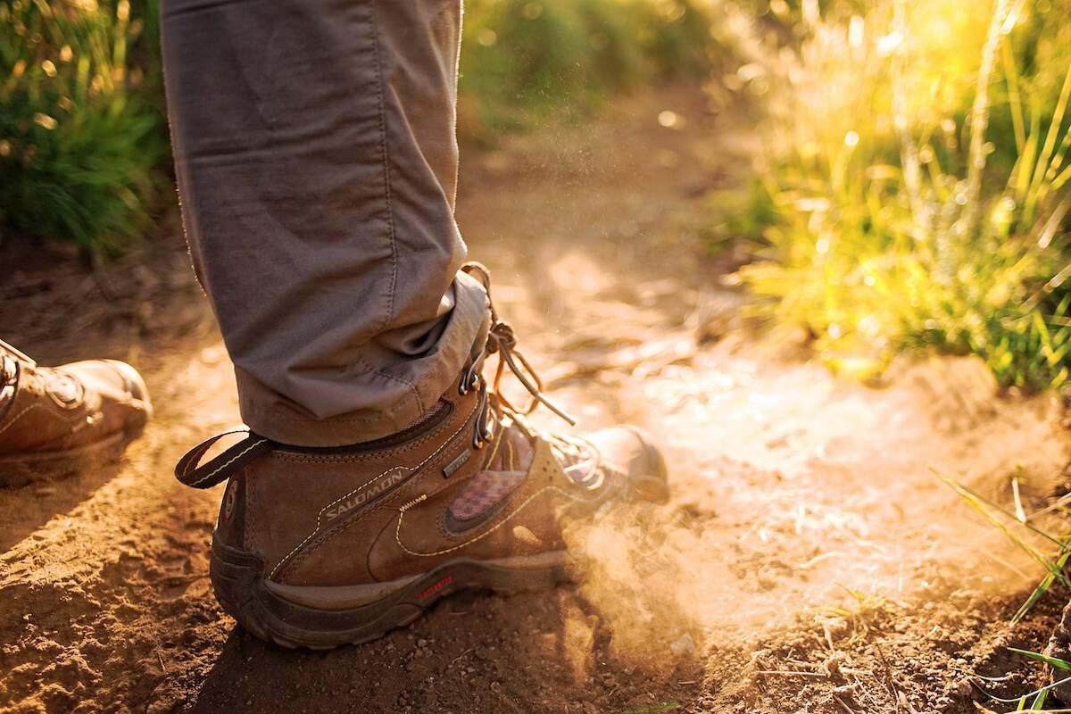 close up of boot hiking on a trail on Long Island NY illuminated by sunlight