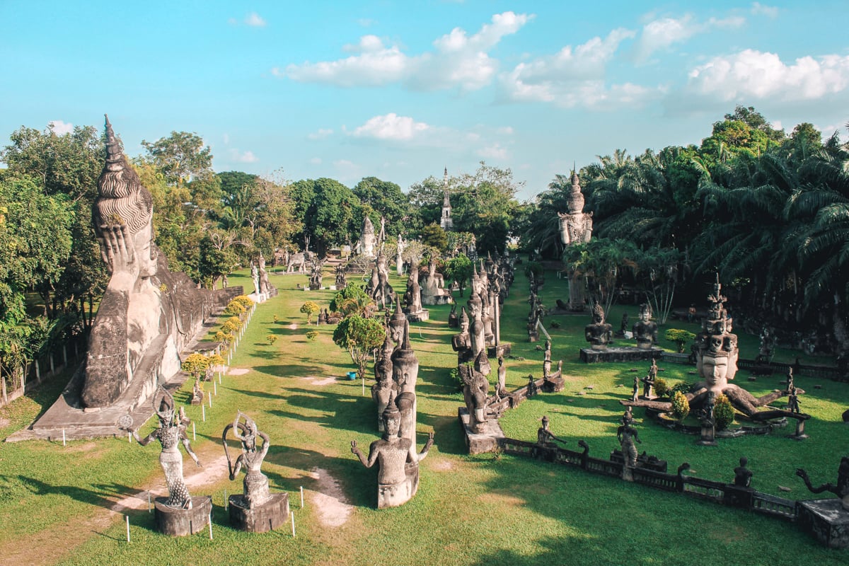 Expansive view of Buddha Park in Vientiane featuring numerous intricate statues and sculptures set against lush greenery, making it a fascinating highlight for any solo female travel itinerary.