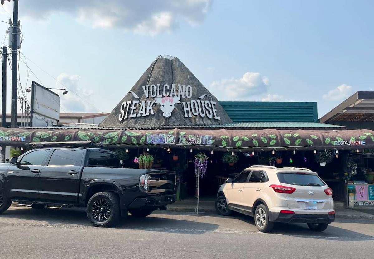 Exterior view of Volcano Steakhouse in La Fortuna, Costa Rica, featuring rustic decor and parked car.