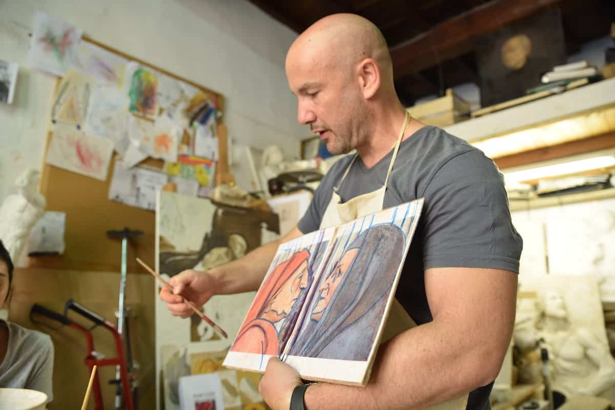 instructor showing fresco paintings during a fresco art class