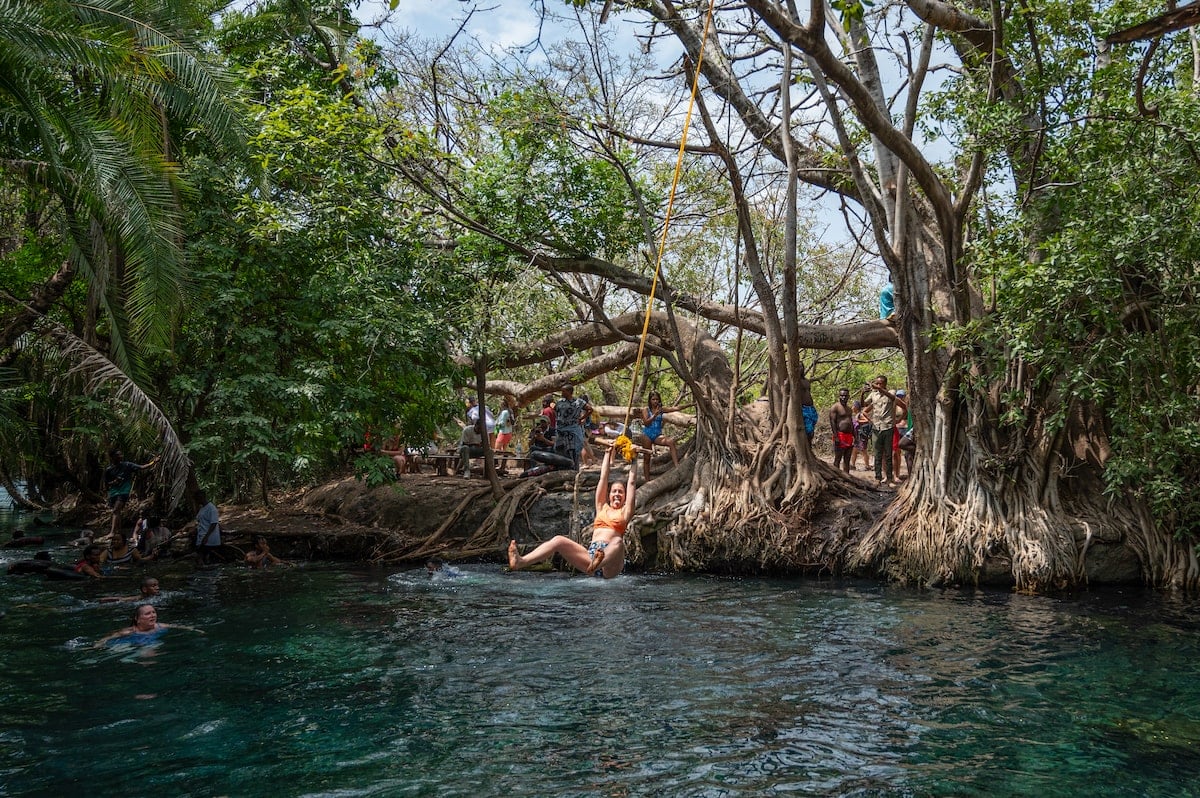 woman swinging on a rope swing at  Kikuletwa Hot Springs (aka Chemka Hot Springs)