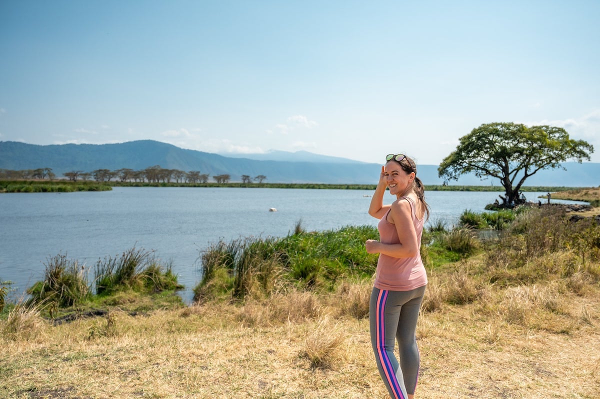 woman looking out over a hippo pool surrounded by acacia trees in Ngorongoro Conservation Area 