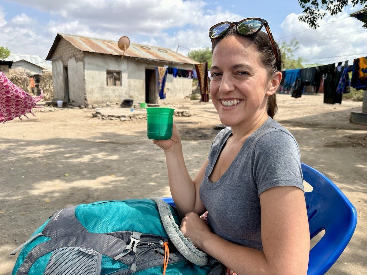 female traveler sipping a fertility drink at a midwife's house in Rundugai Village in Tanzania