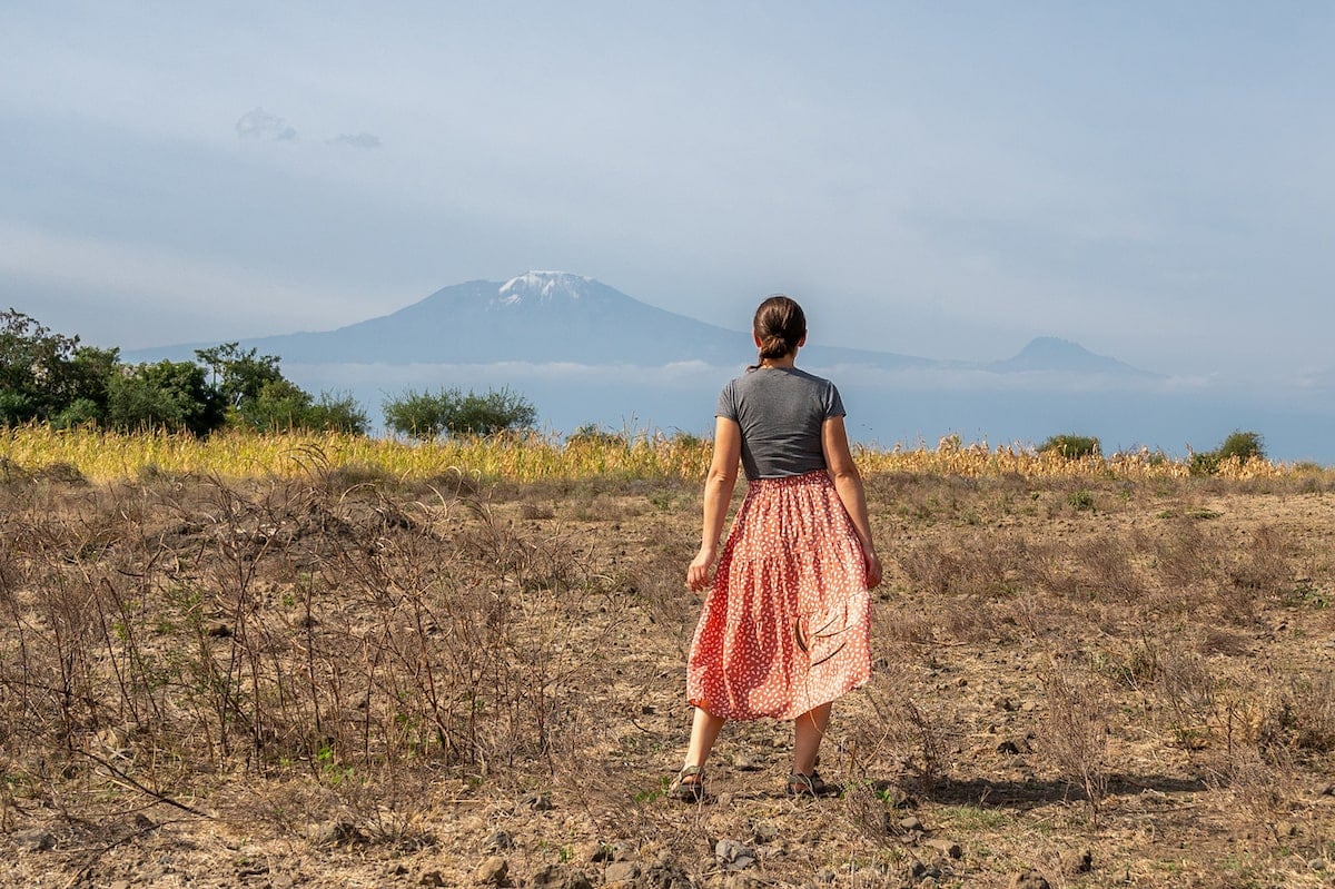 solo female traveler in Tanzania taking in a view of Mount Kilimanjaro from the side of the road