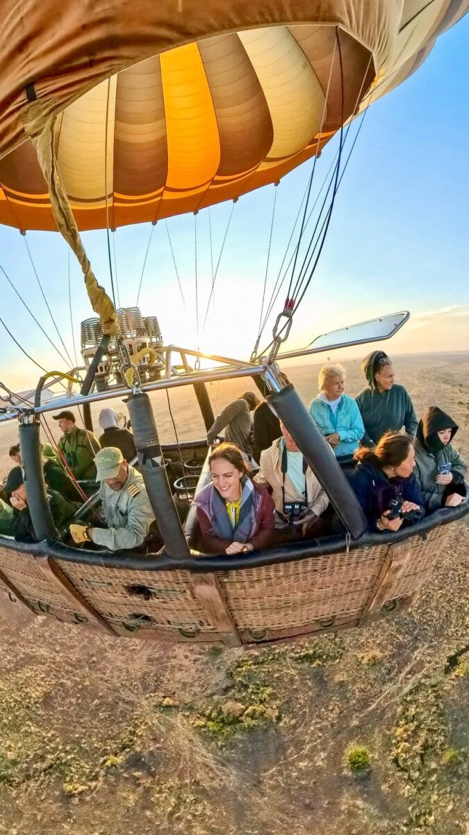 woman smiling while floating above the Serengeti on a sunrise hot air balloon safari in Tanzania