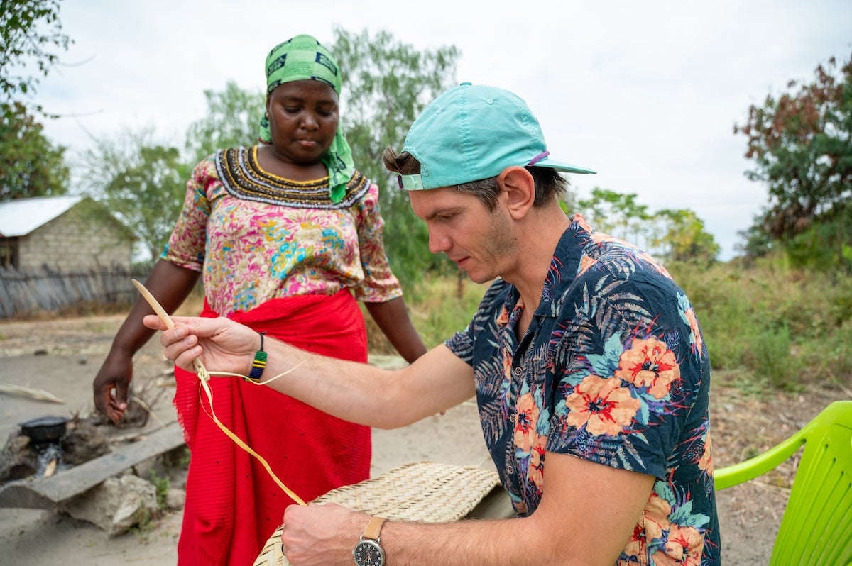 traveler learning how to weave palm leaves during a cultural experience near Lake Manyara in Tanzania