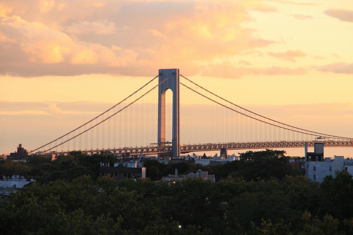 Verrazzano-Narrows Bridge at sunset illuminated in yellow and orange