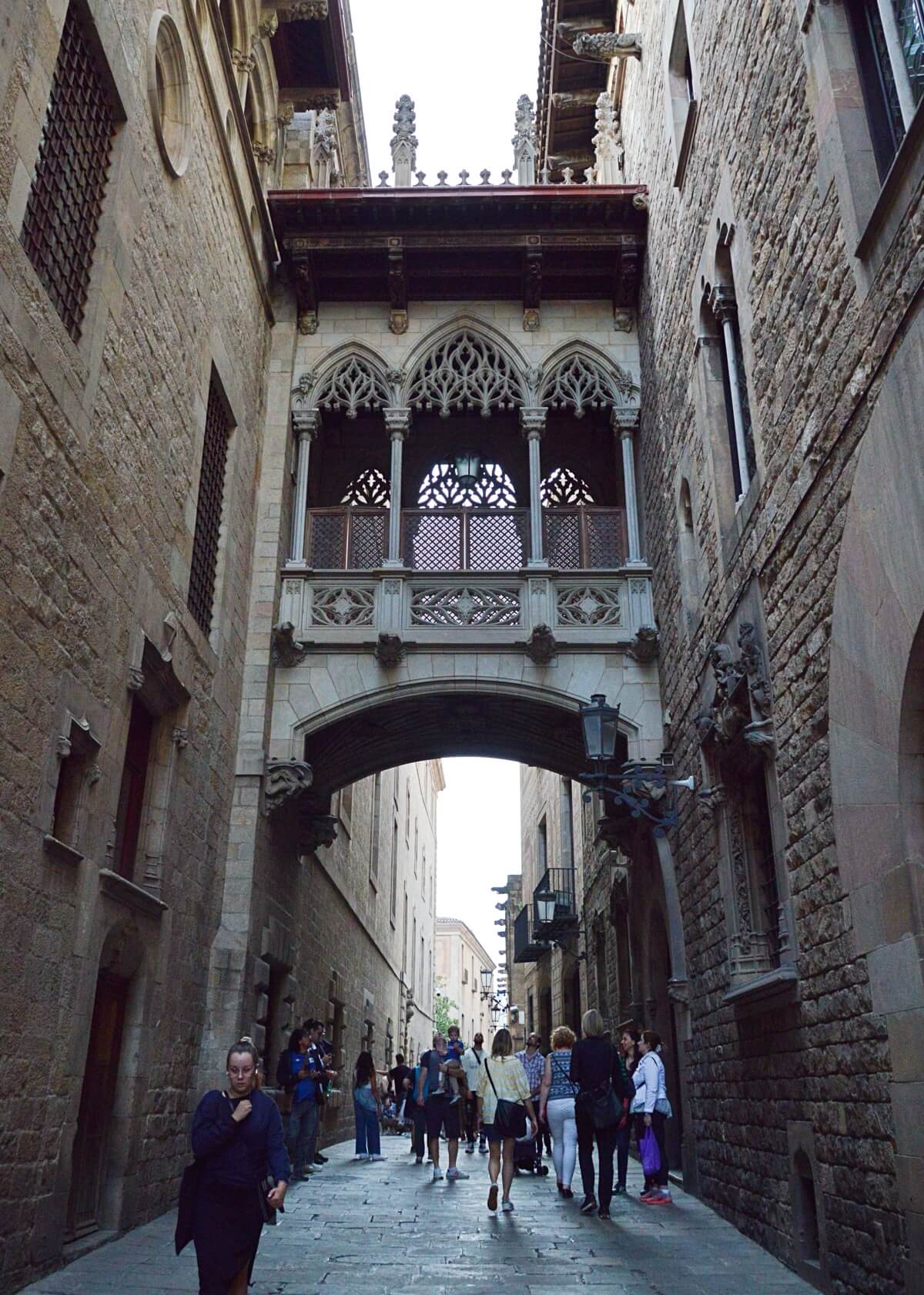 Pont del Bisbe, a picturesque Gothic bridge in Barcelona’s Gothic Quarter, showcasing its intricate stone carvings and neo-Gothic architecture as it arches between historic buildings.