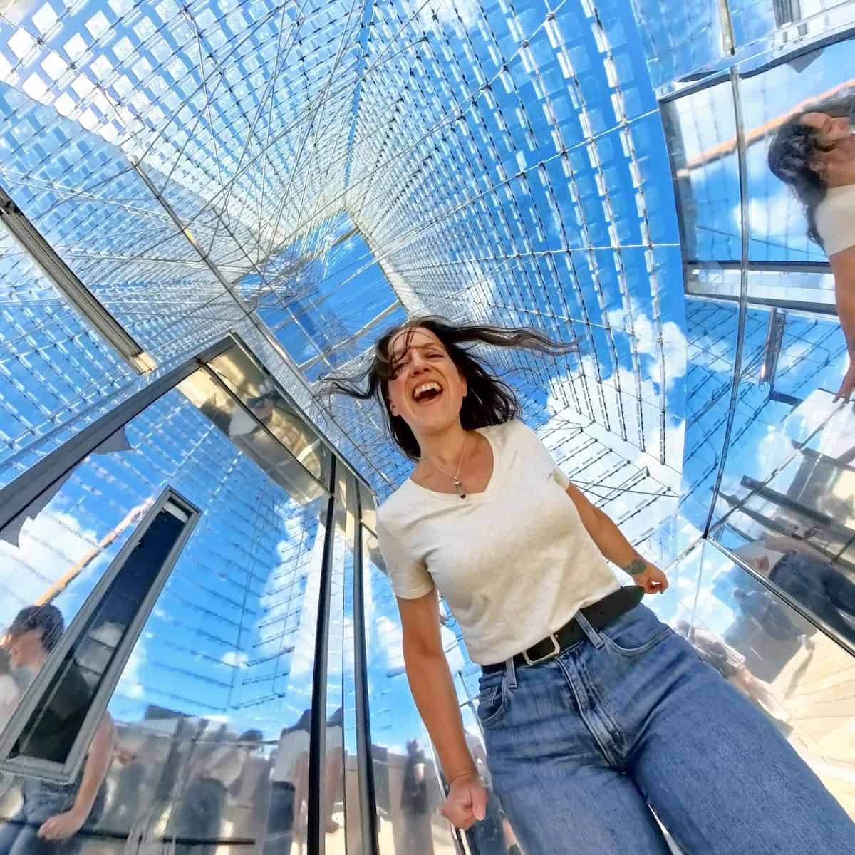 solo female traveler using a 360 camera to take with the clouds above her head