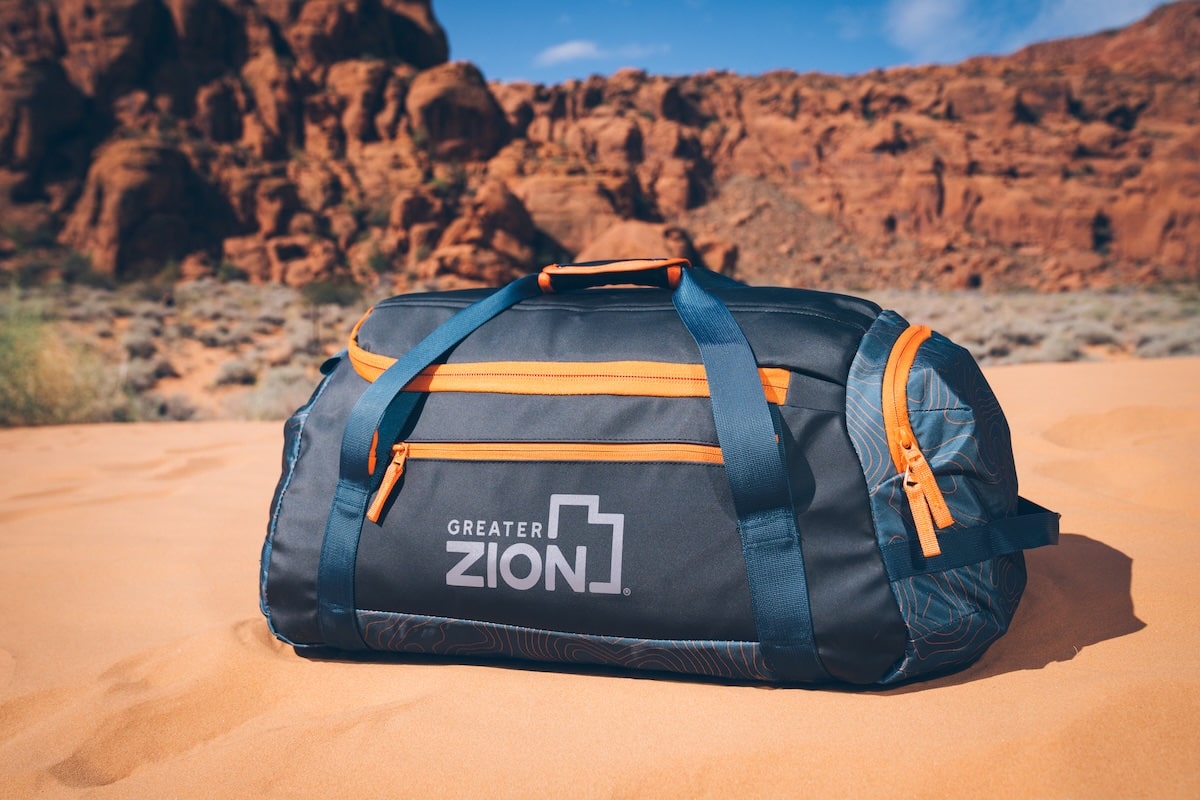 Quest Duffel Bag from Coalatree and Greater Zion in the sand surrounded by red rock mountains