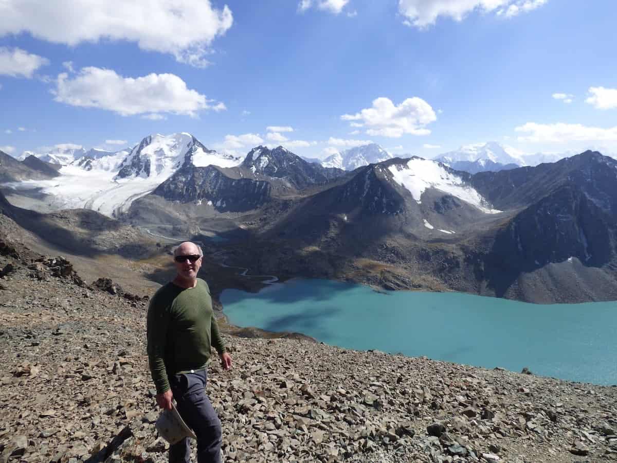 Substack writer Tim Leffel standing in front of a blue lake in Kyrgyzstan