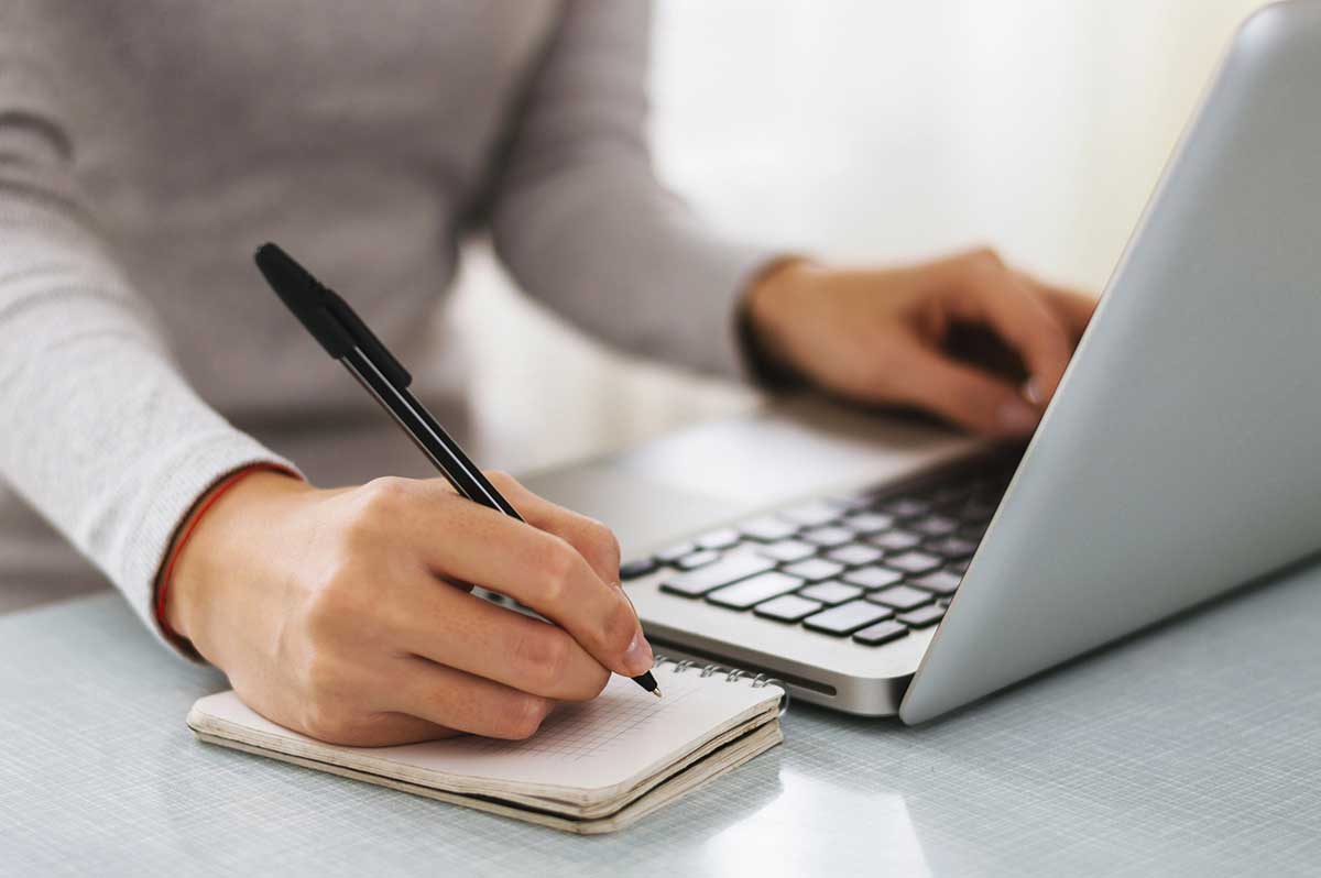 Businesswoman hand working with computer and writing a blogging content plan.
