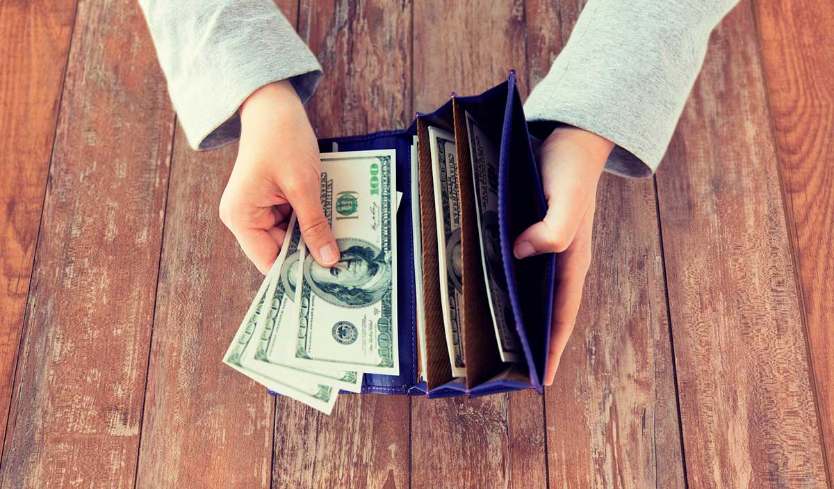 Close up of woman hands with wallet and money.