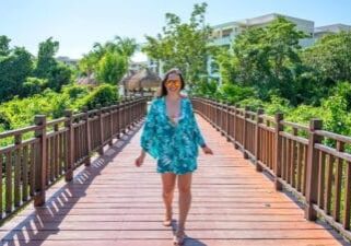 solo female traveler walking alone through palm trees in Mexico